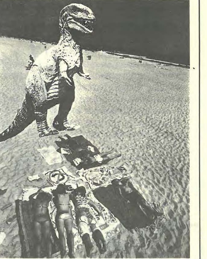 Un dinosaurio de juguete sobre la arena, entre bañistas diminutos